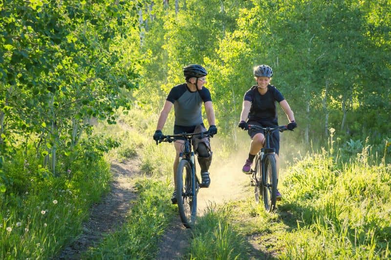 older man and young woman bike riding older man and young woman bike riding
