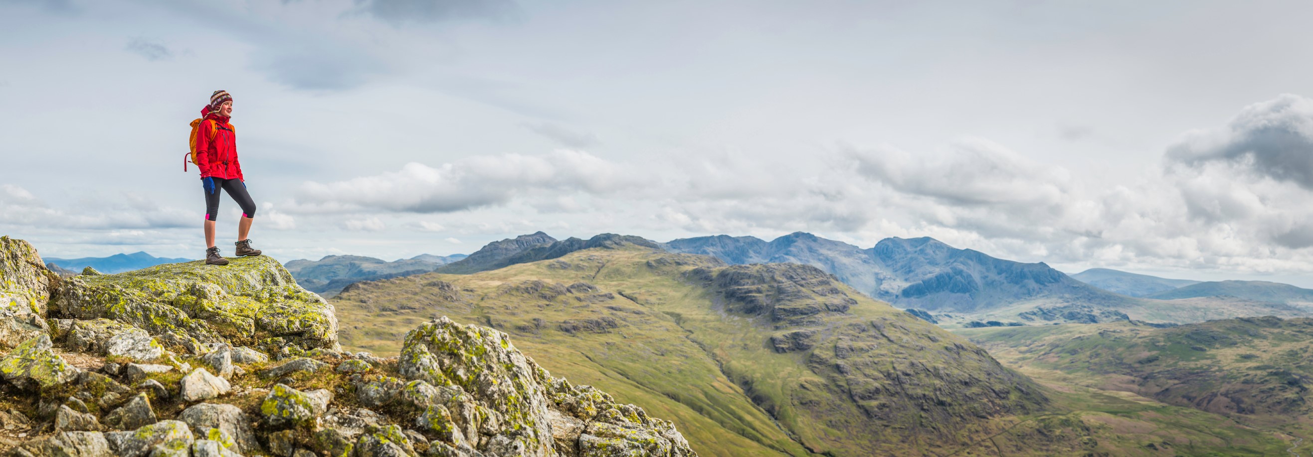 A female hiker stands in awe of mountain plains