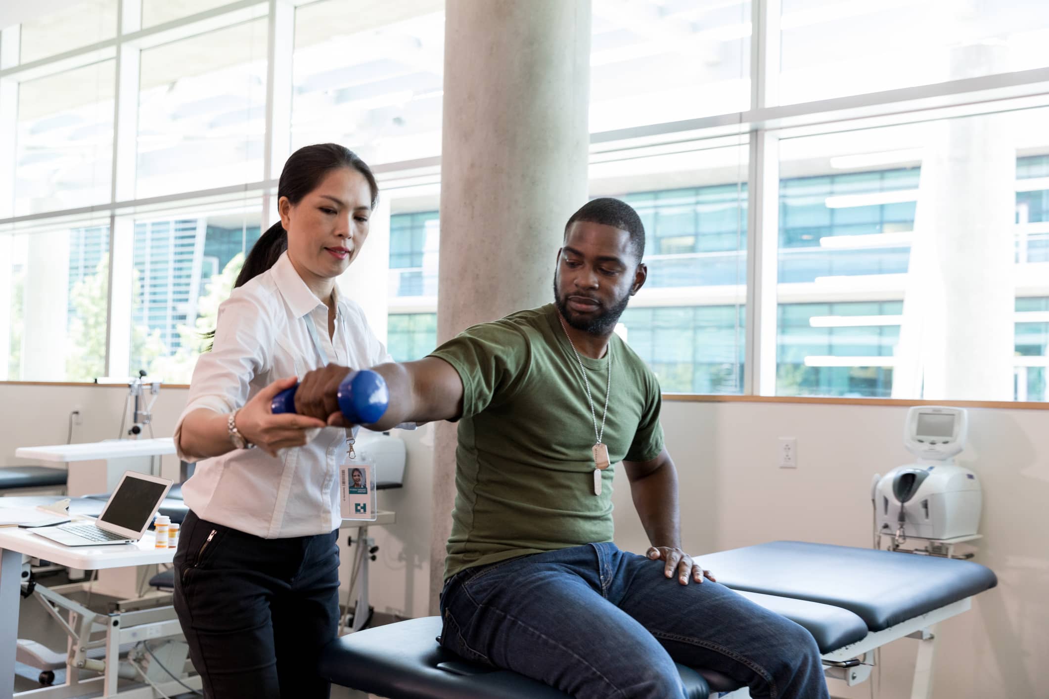 Travel physical therapist assisting a patient with shoulder exercises