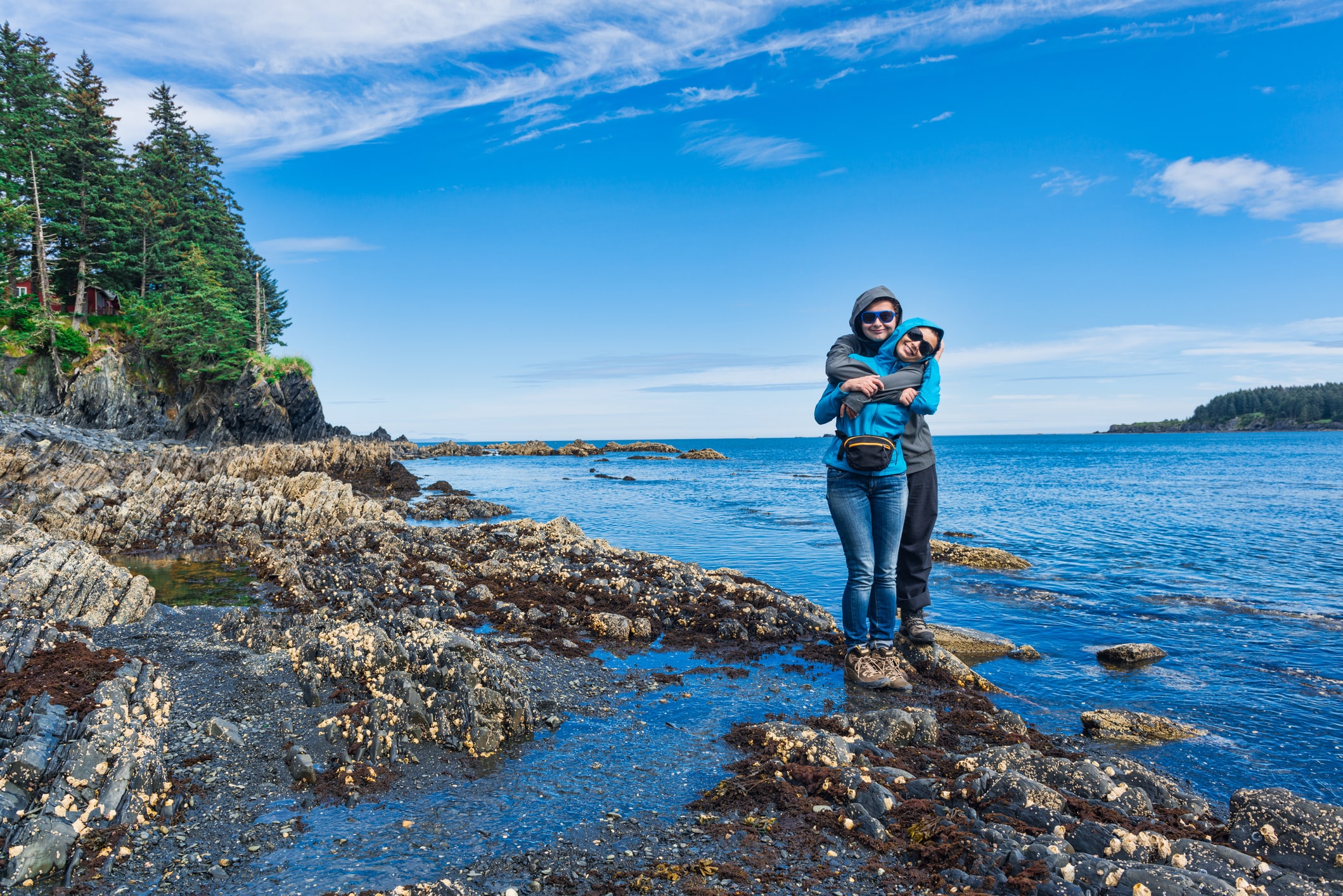 2 women hugging in front of glacier park in alaska 2 women hugging in front of glacier park in alaska