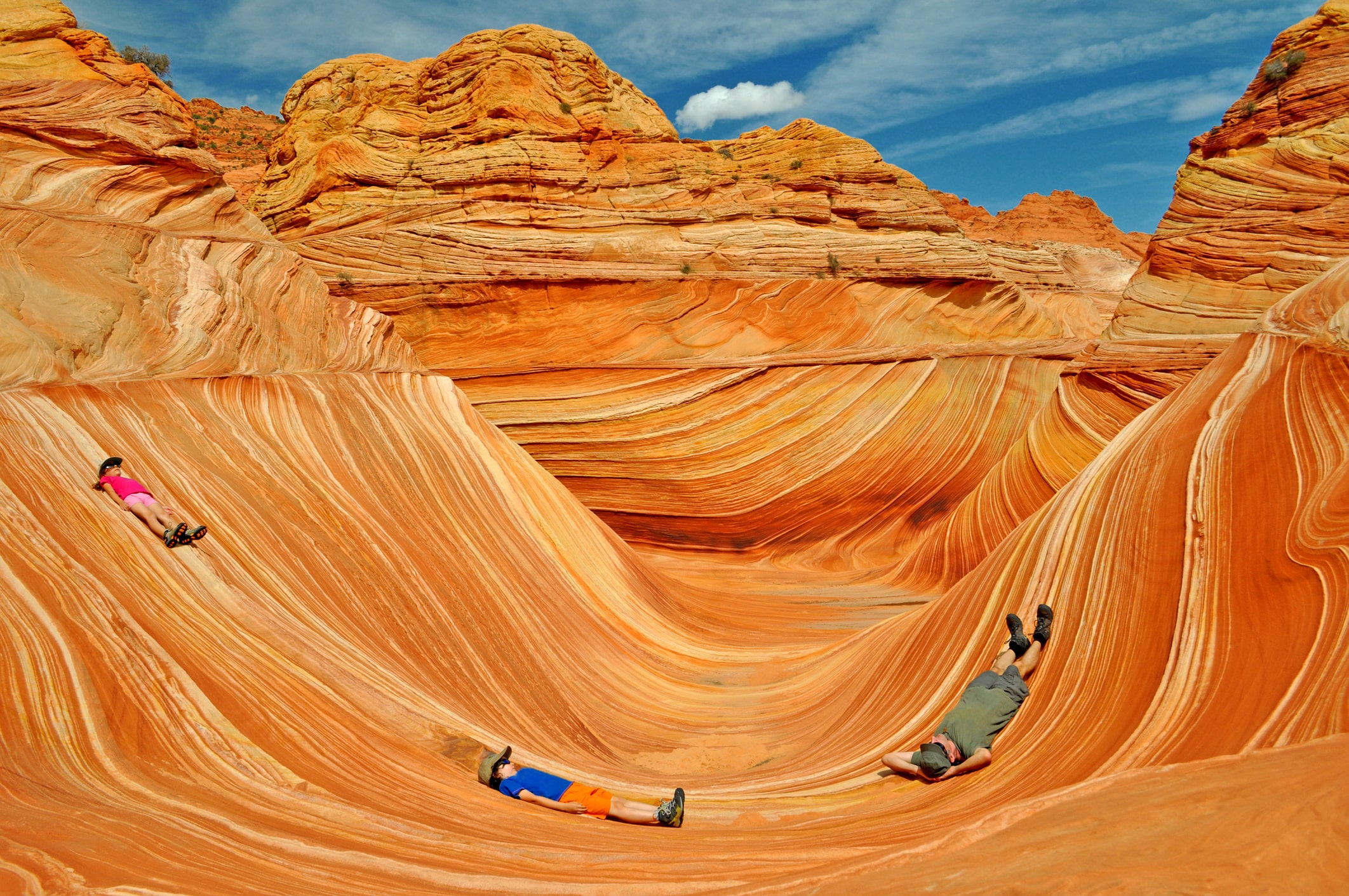 family of 3 laying in waves of rock formations in arizona desert family of 3 laying in waves of rock formations in arizona desert