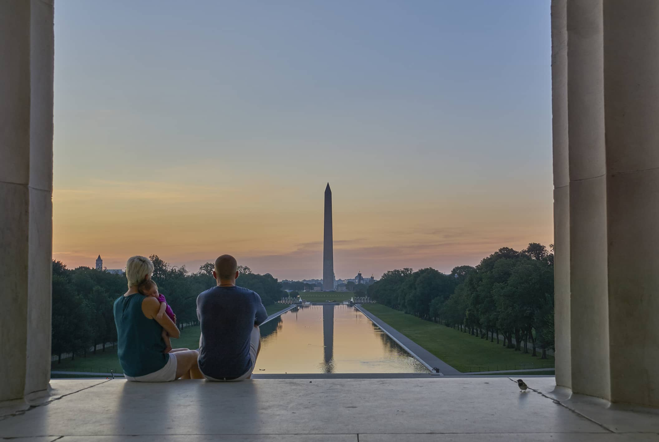 Couple with a Baby at the Lincoln Memorial with the Washington Memorial in the Background at Sunrise in Washington DC Couple with a Baby at the Lincoln Memorial with the Washington Memorial in the Background at Sunrise in Washington DC