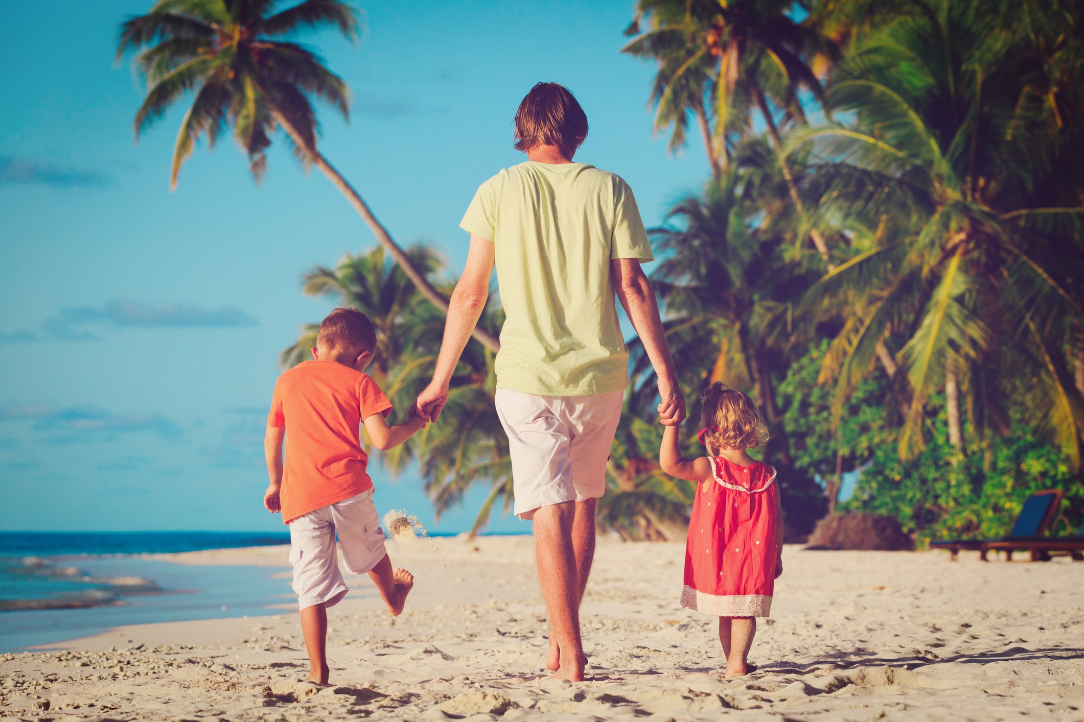 dad and 2 kids walking on beach beneath palm trees in florida dad and 2 kids walking on beach beneath palm trees in florida
