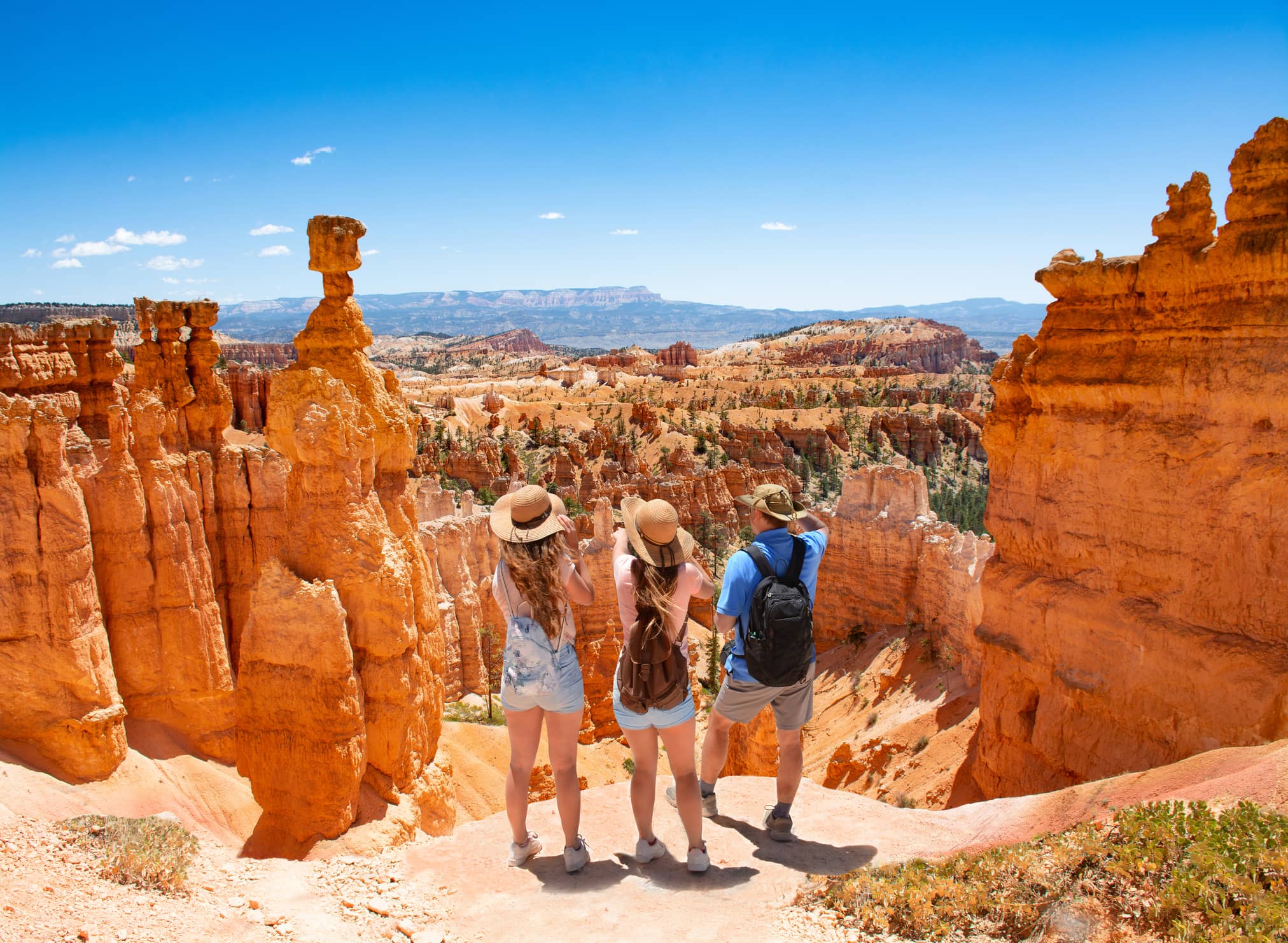 Family standing on top of mountain looking at beautiful red mountains. Family standing on top of mountain looking at beautiful red mountains.